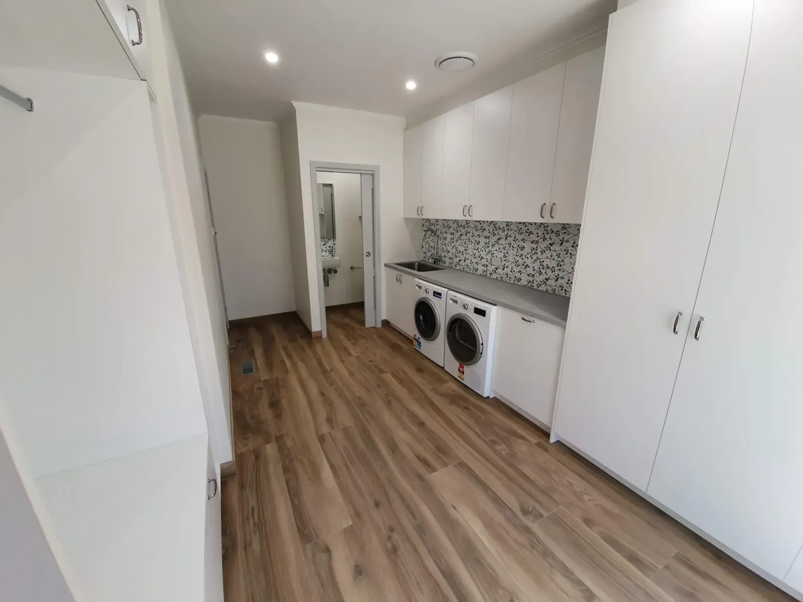 laundry room with built-in cabinets and a stacked counter run