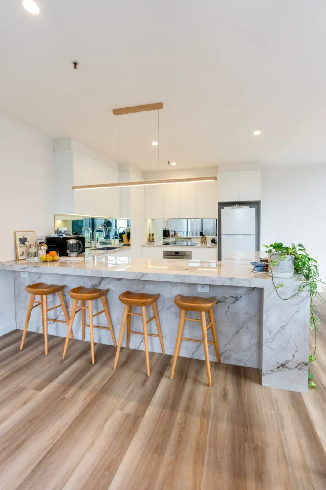 kitchen island with a marble-look waterfall top and seating for four