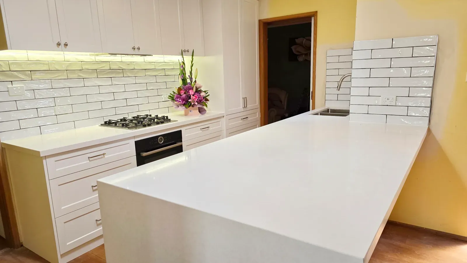 shaker kitchen with a waterfall island, backsplash going in